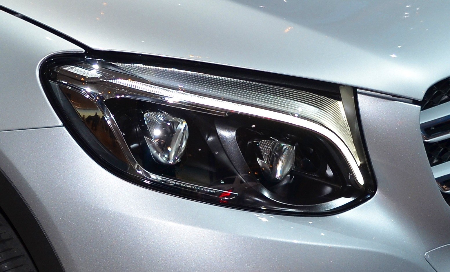 Close-up of modern SUV headlight with LED elements and chrome accents