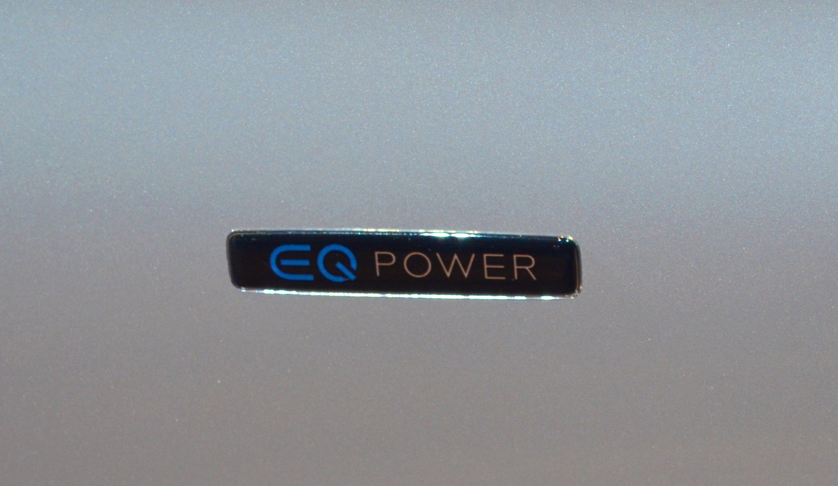 Close-up of EQ Power hybrid emblem badge on car body