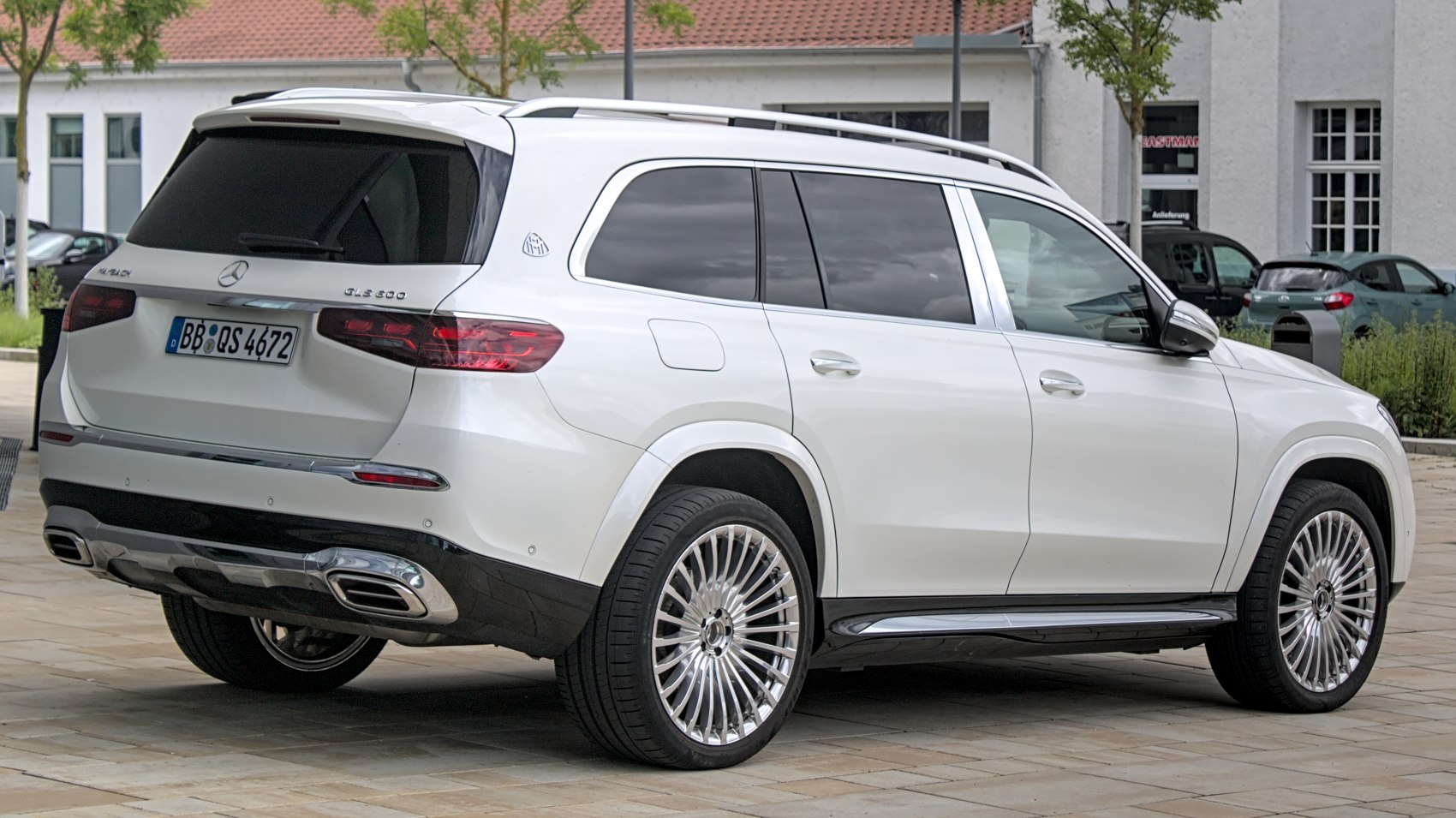 SUV rear profile with chrome dual exhaust and multi-spoke wheels