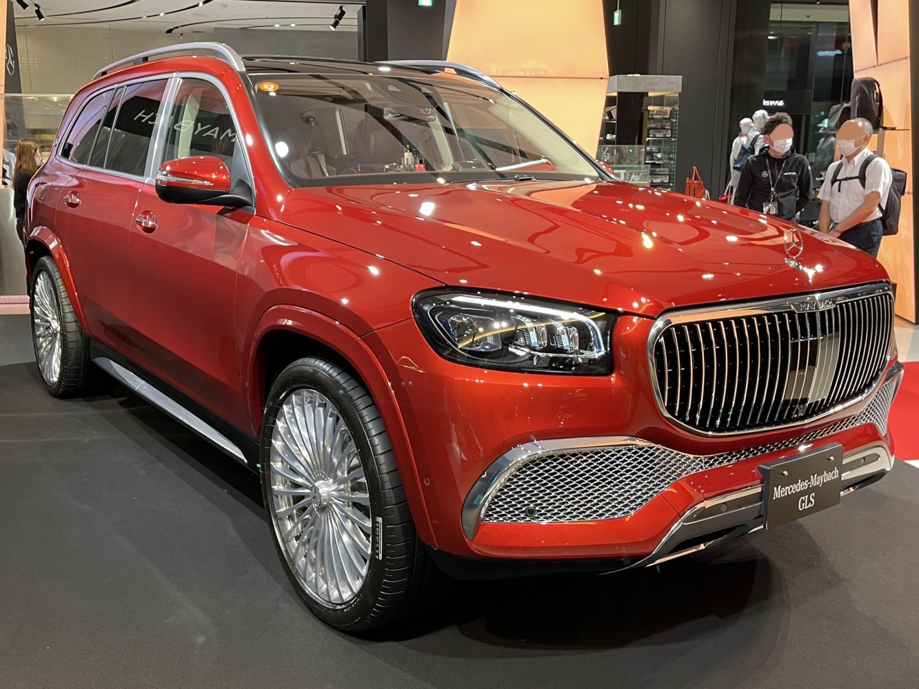 Luxury SUV with large vertical chrome grille and intricate multi-spoke alloy wheels