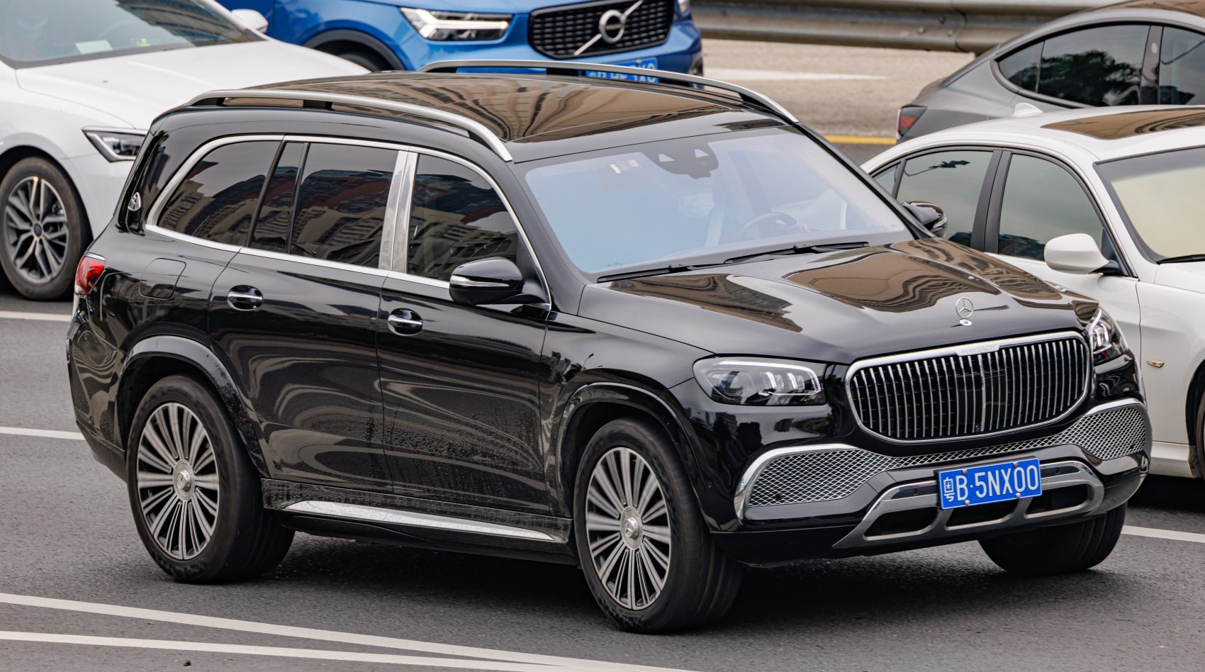 Glossy black luxury SUV with vertical slat grille and multi-spoke alloy wheels