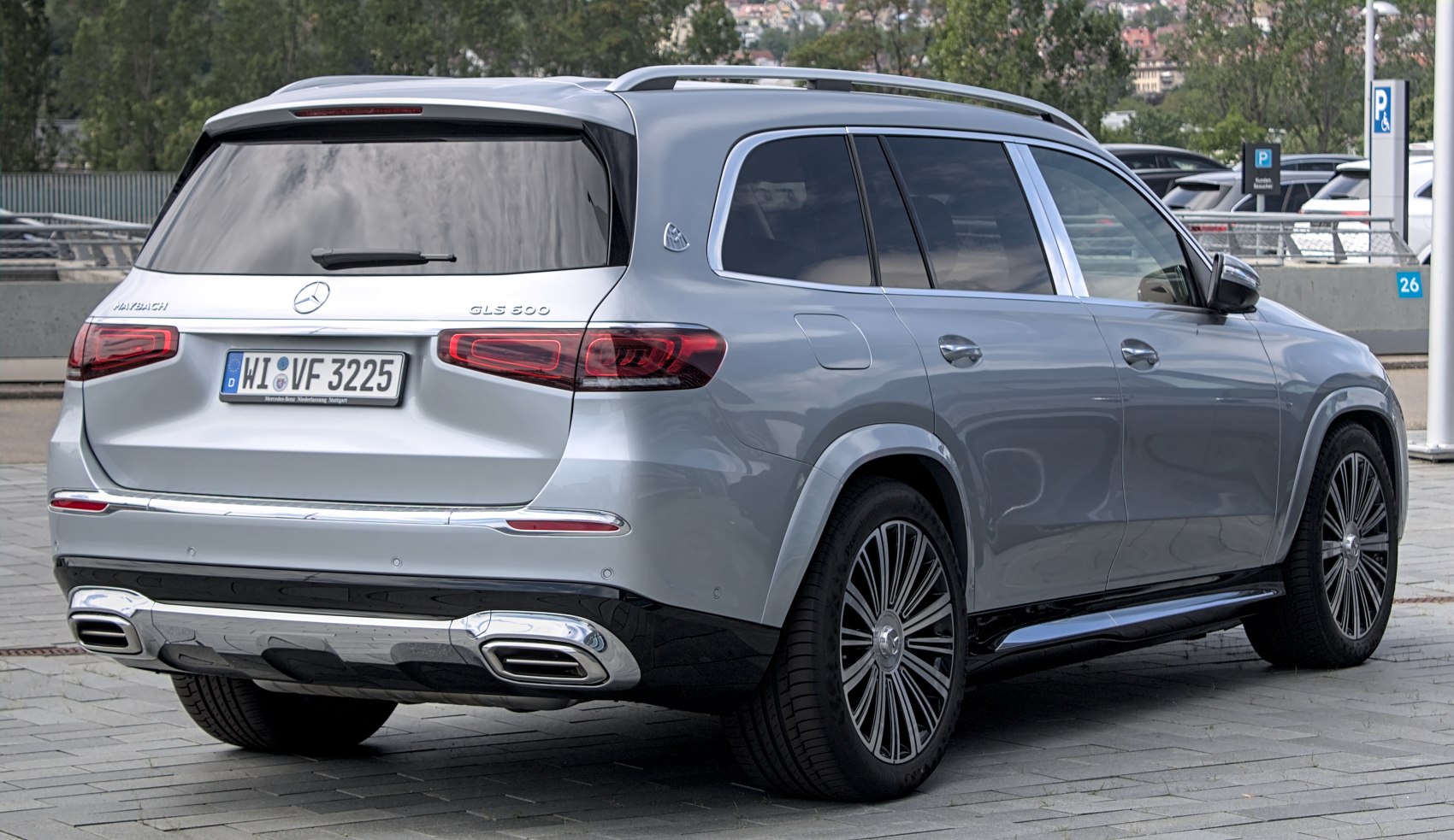 Luxury SUV rear with sleek taillights, chrome exhaust trim, tinted windows.