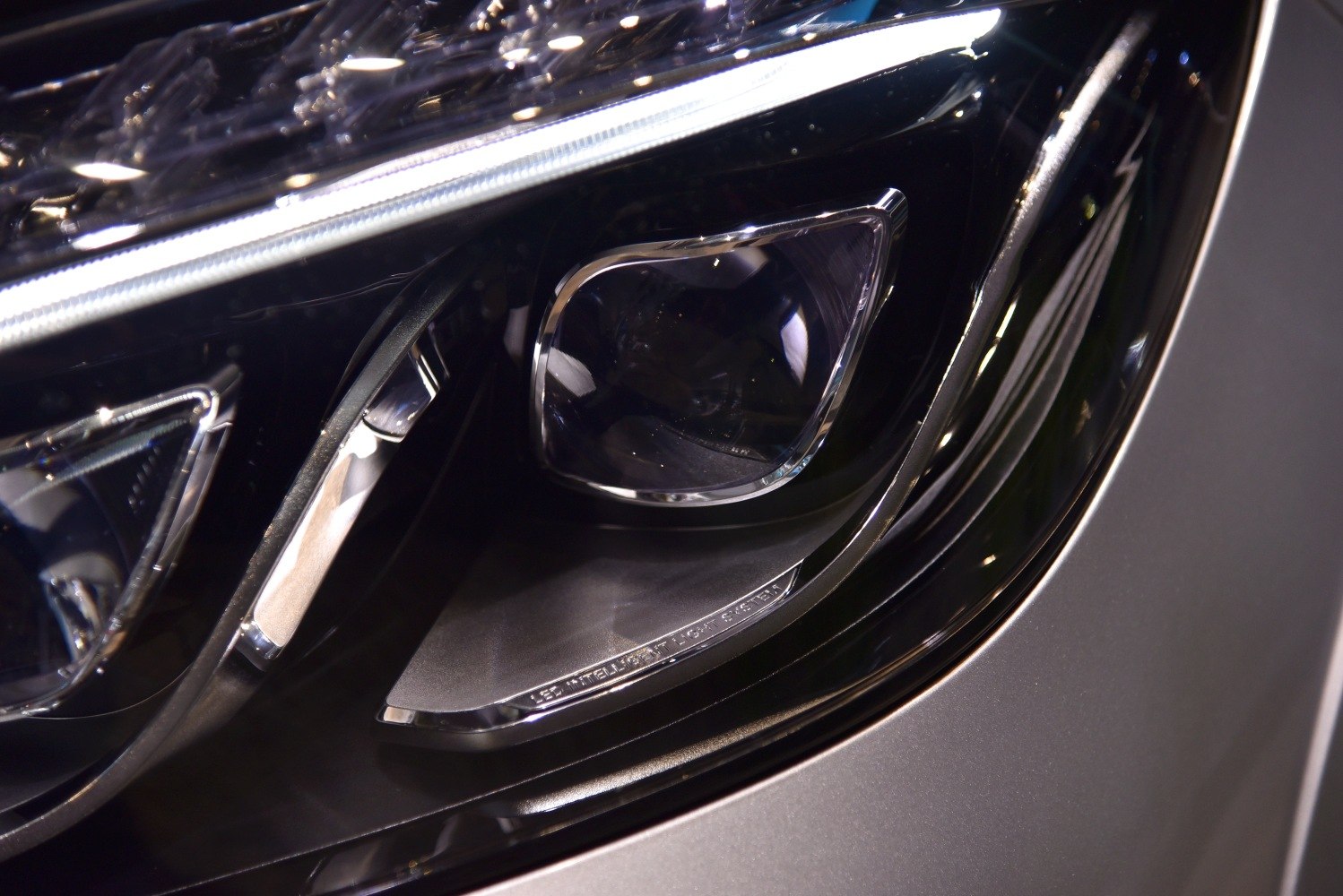 Close-up of advanced front headlight with projector and LED strip lighting