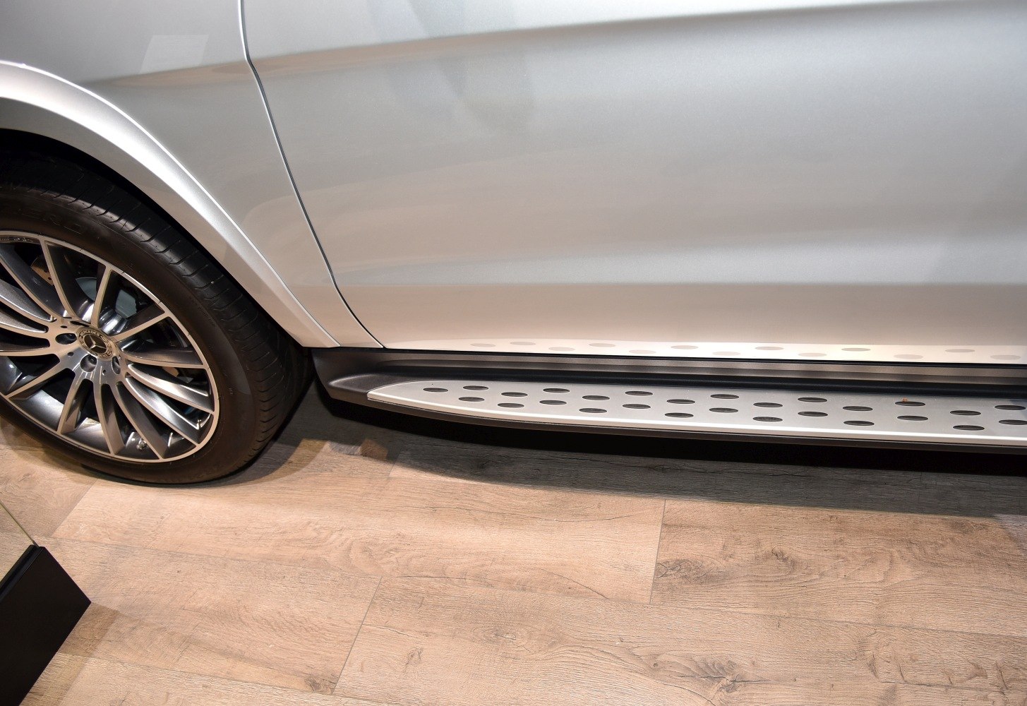 Close-up of alloy wheel and perforated running board on SUV side