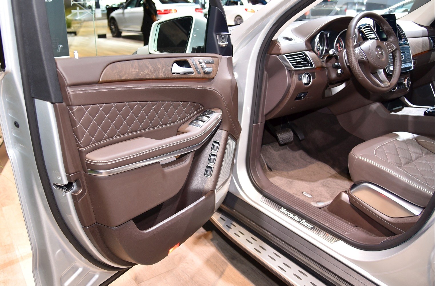 Brown quilted leather upholstery with wood trim and modern control buttons