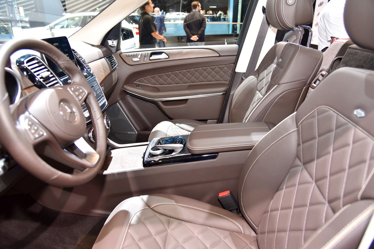 Brown quilted leather seats and wood-accented luxury SUV interior with advanced controls