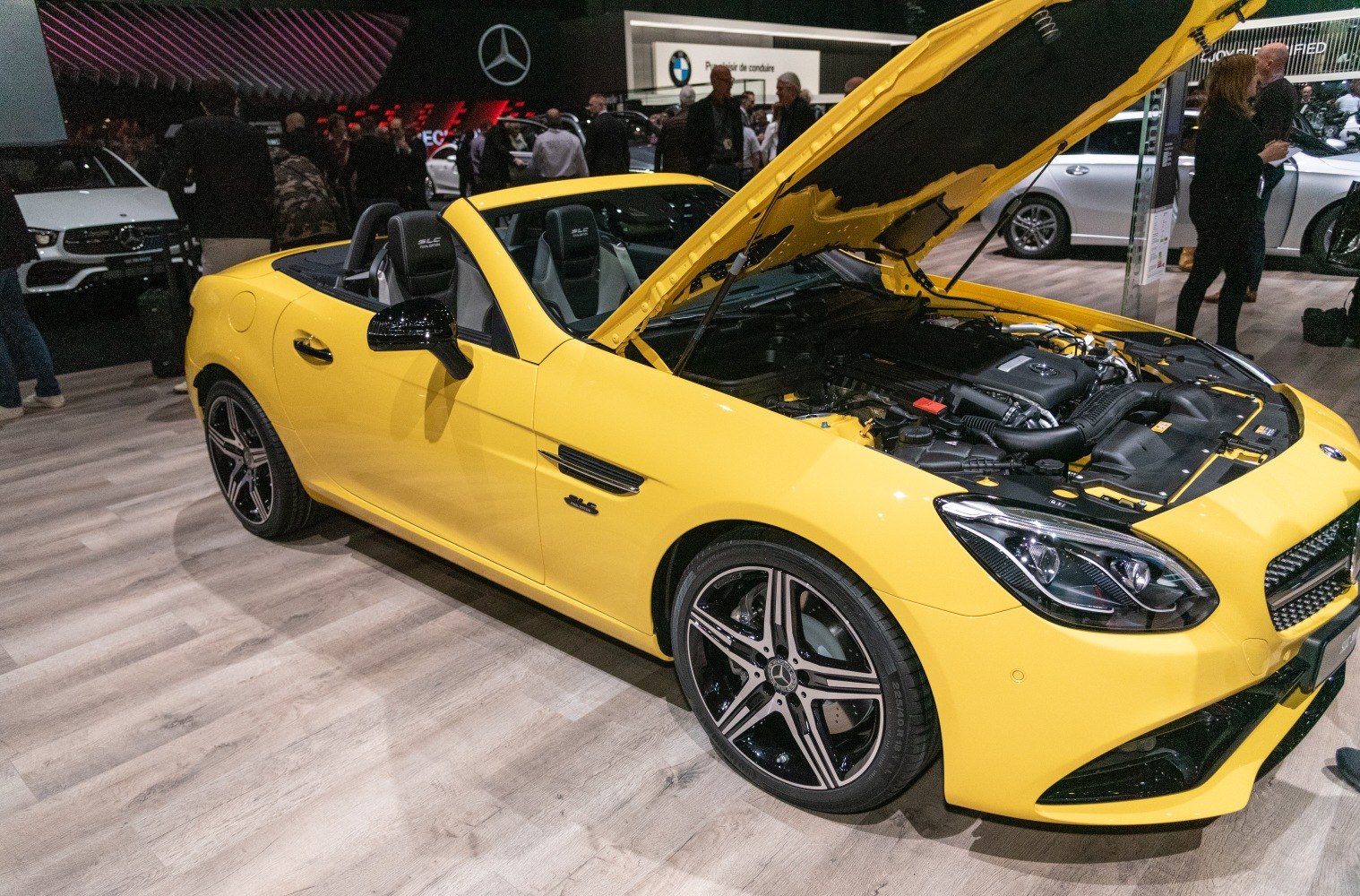 Yellow convertible with open hood showing engine and alloy wheels