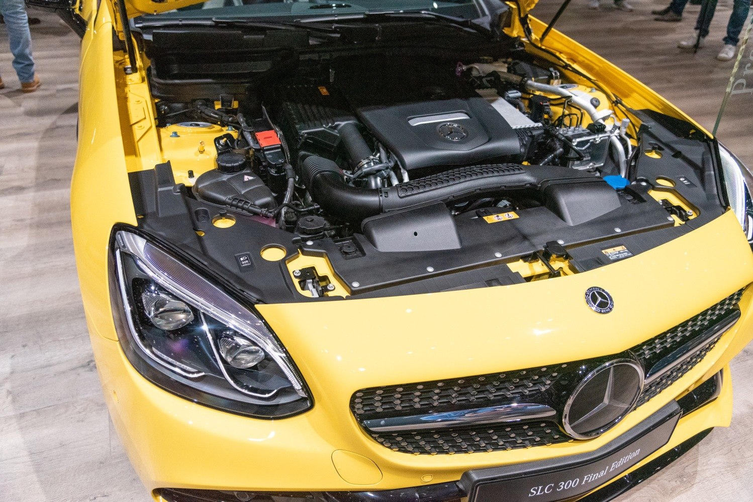 Engine bay and front grille of a yellow sports coupe