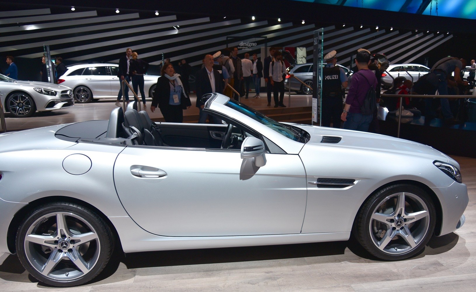 Silver convertible with open roof and five-spoke alloy wheels side view
