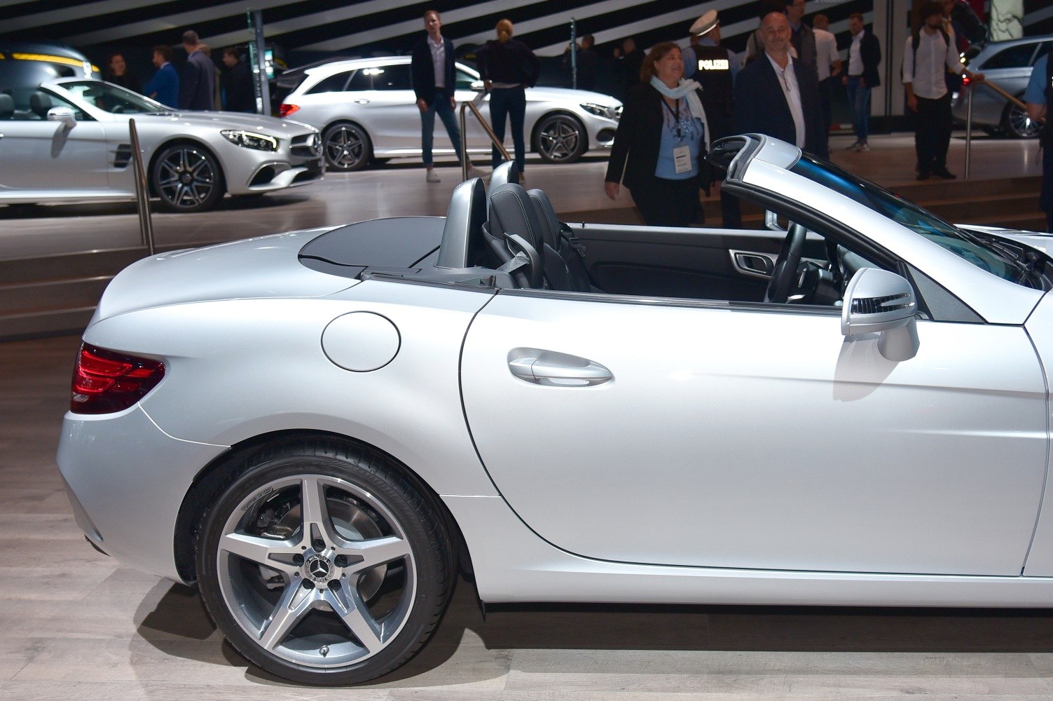 Rear side view of convertible roadster with alloy wheels and open rooftop