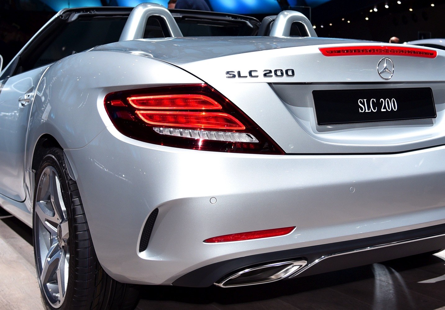Rear view of silver sporty convertible with distinct LED tail lights and dual exhaust