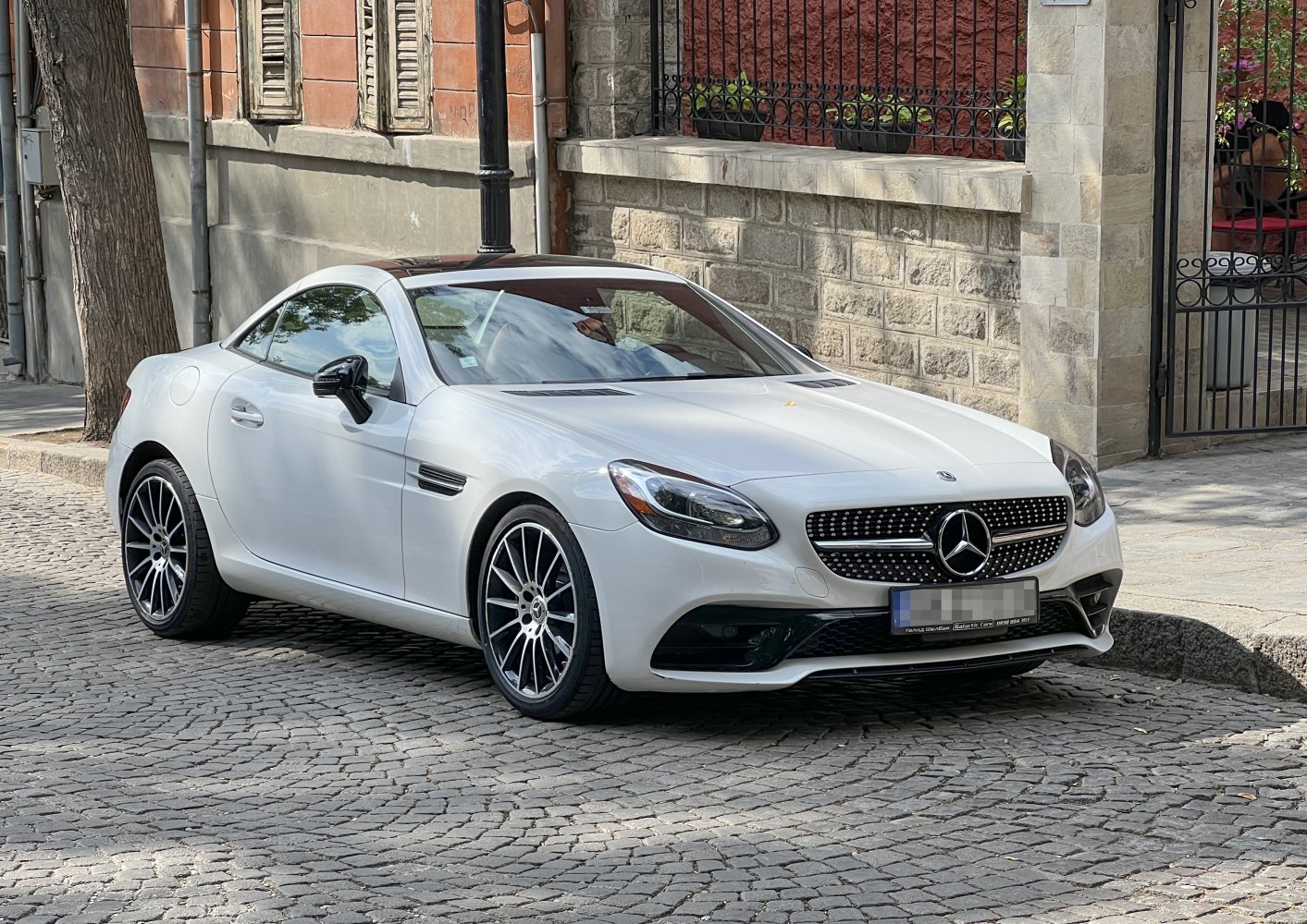 White sleek sports coupe front side with diamond grille and alloy wheels