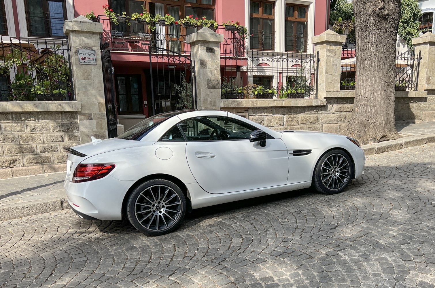 Side view of sleek white sport coupe with multi-spoke wheels