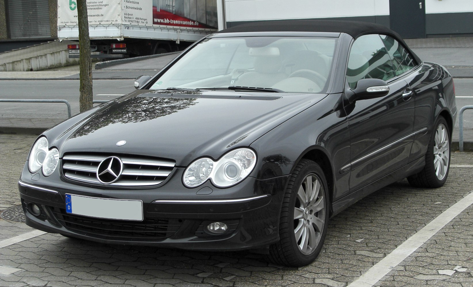 Front angled view of a convertible with dual round headlights and grille