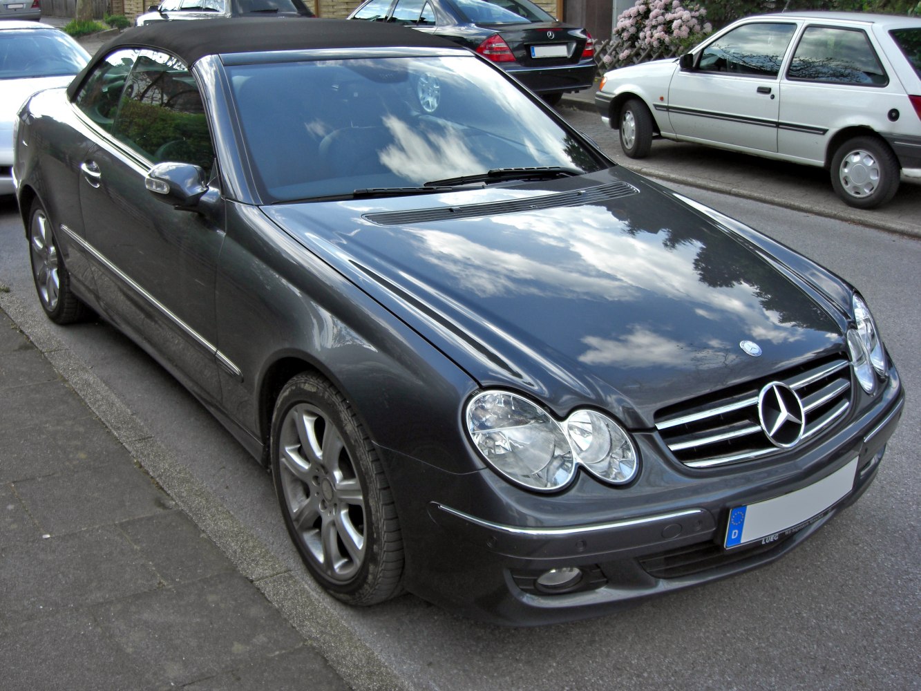 Front view of a convertible with dual rounded headlamps and black soft top
