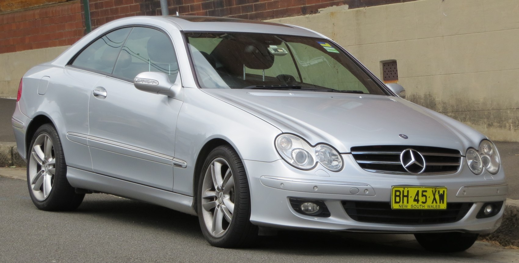 Silver coupe with dual round headlights and alloy wheels.