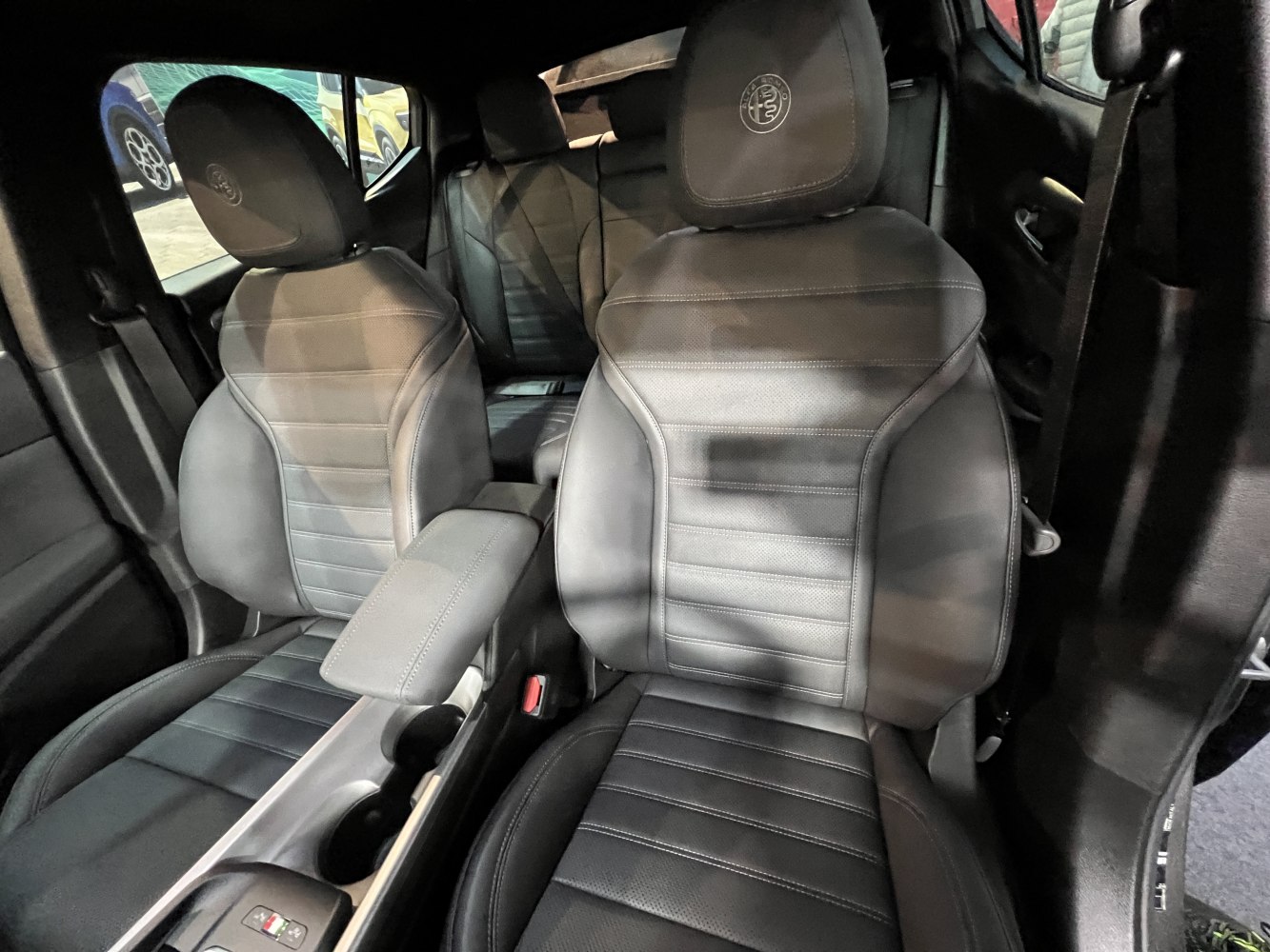 Black leather front seats with stitching and center console with cup holders