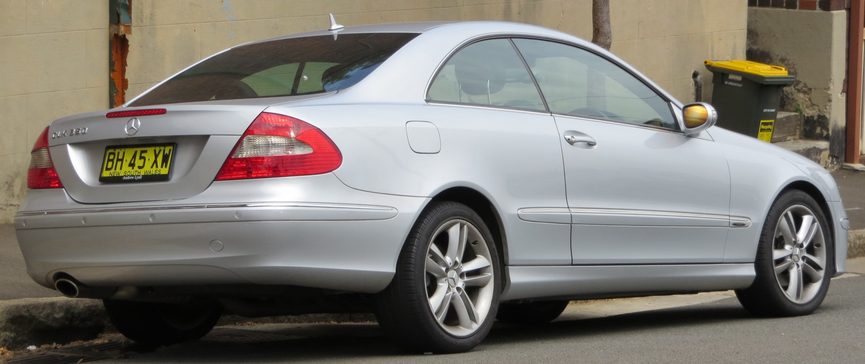 Rear side view of silver two-door coupe with alloy wheels and smooth contours