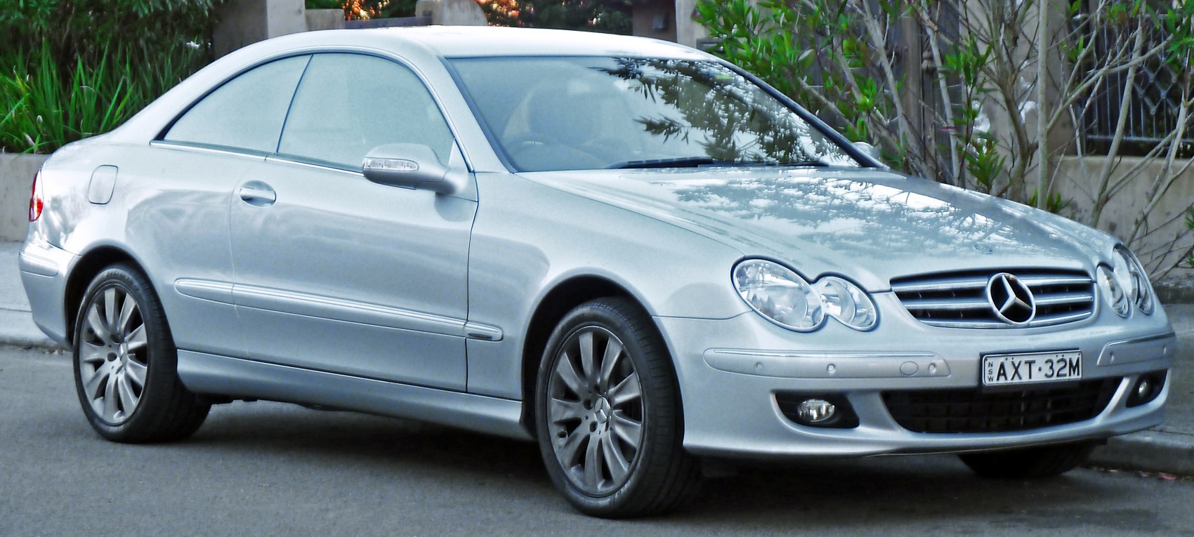 Silver sports coupe with dual round headlights and multi-spoke alloy wheels