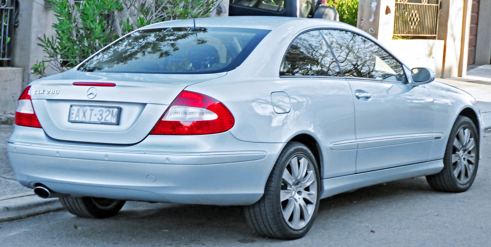 Rear side view of silver Mercedes-Benz coupe with distinct tail lights and alloy wheels