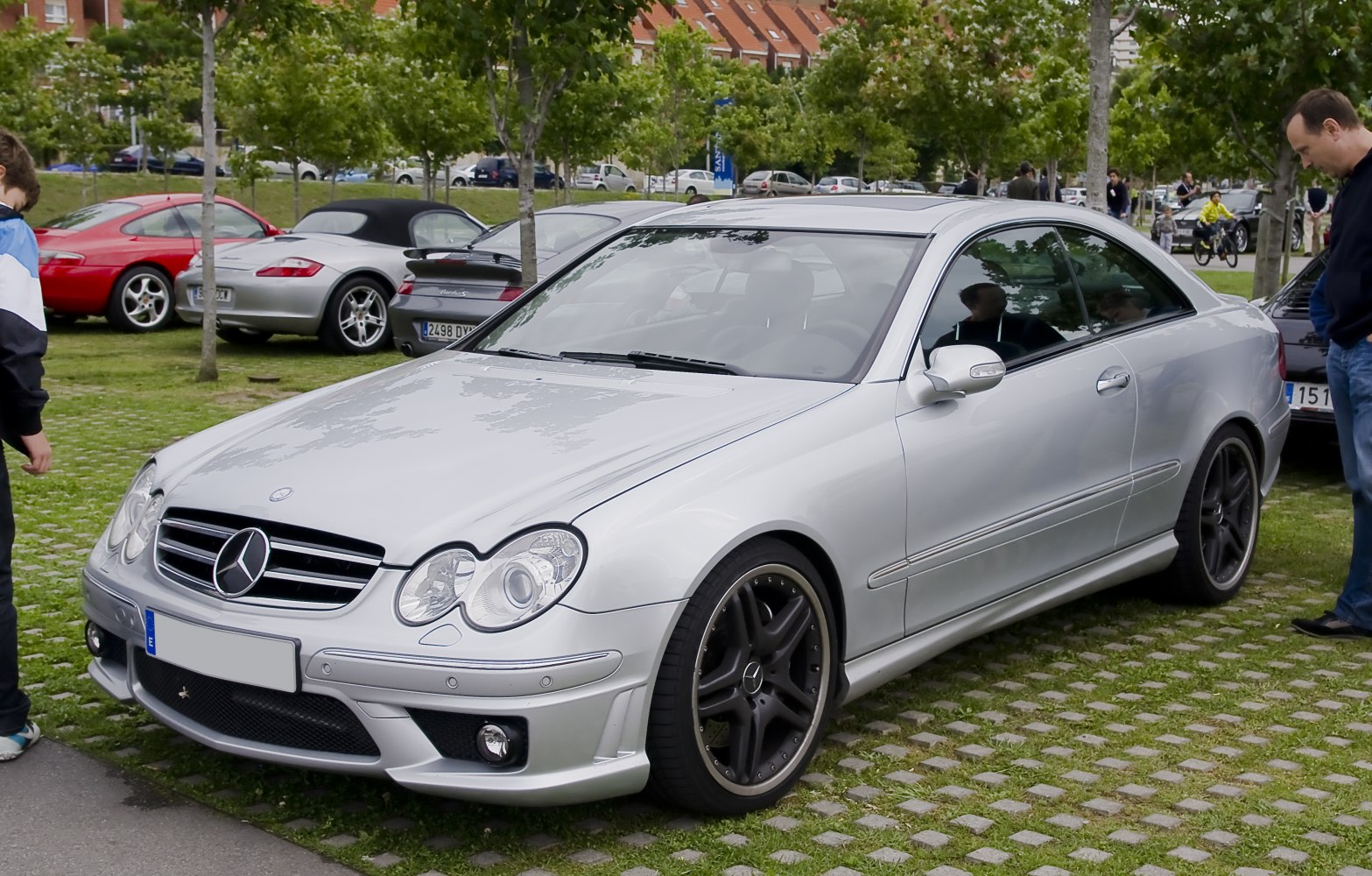 Silver Mercedes coupe with sporty wheels and distinctive twin circular headlights.