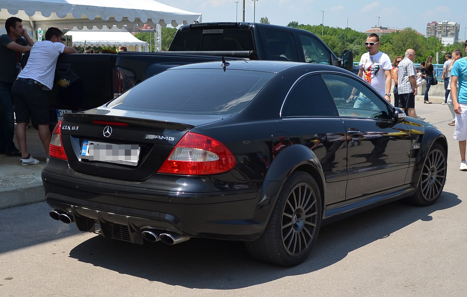 Rear side view of a sporty 2005 black coupe with quad exhausts