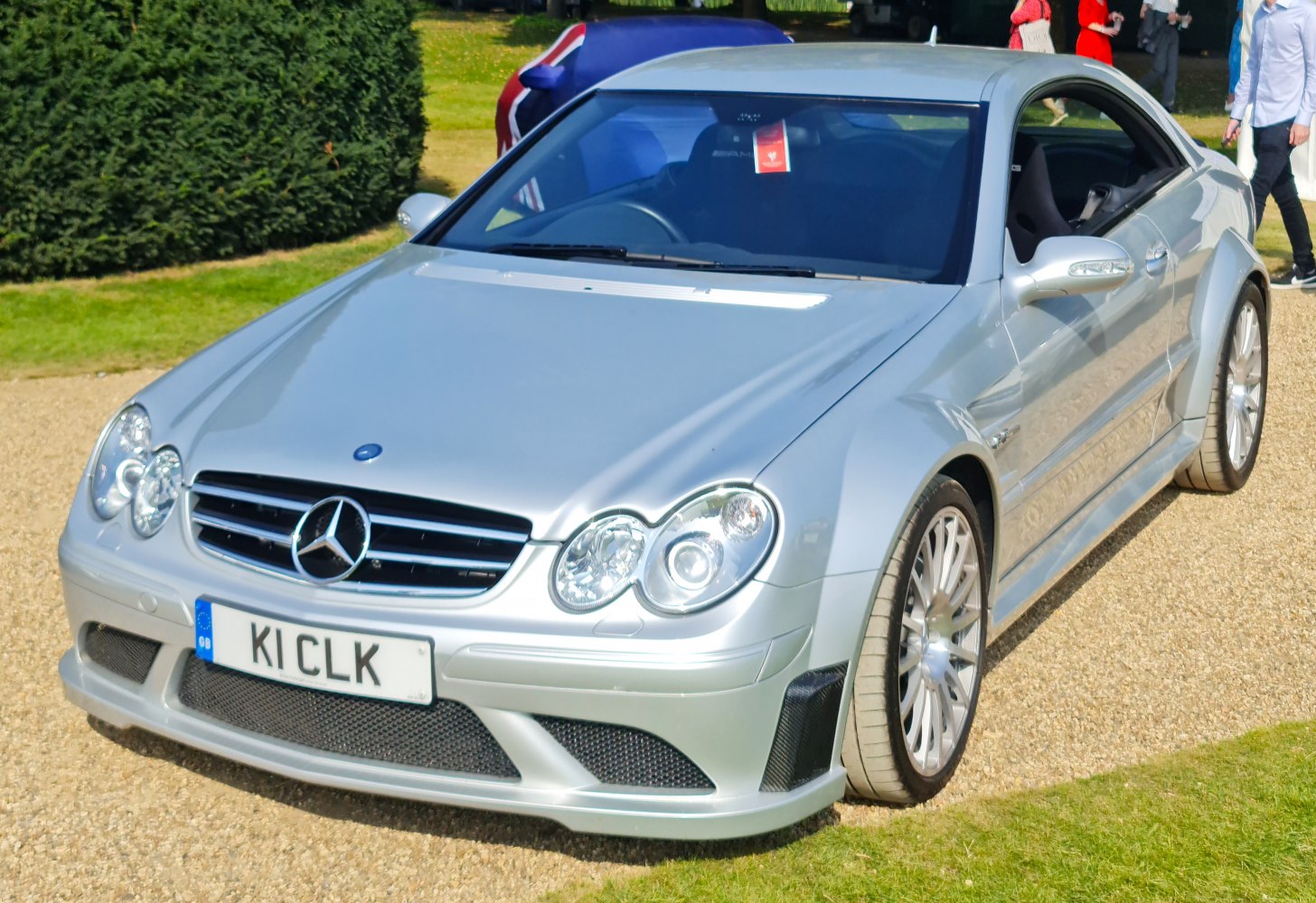 Silver sports coupe front with quad round headlights and AMG-style bumper