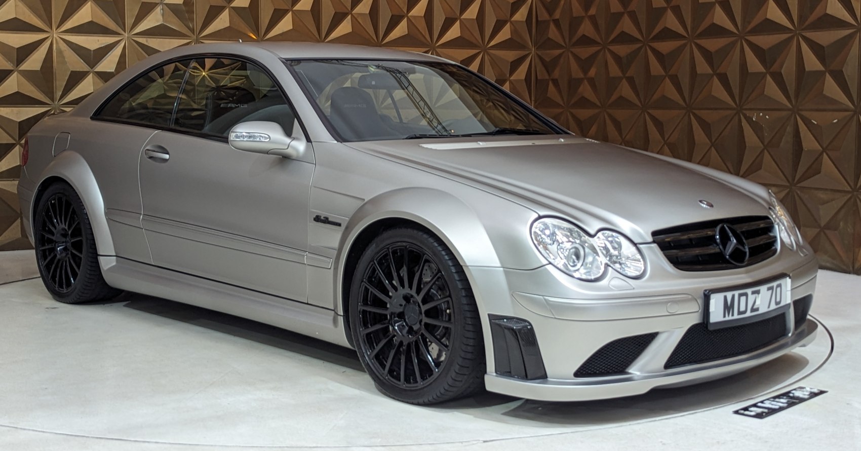 Silver sports coupe with AMG styling and black multi-spoke wheels
