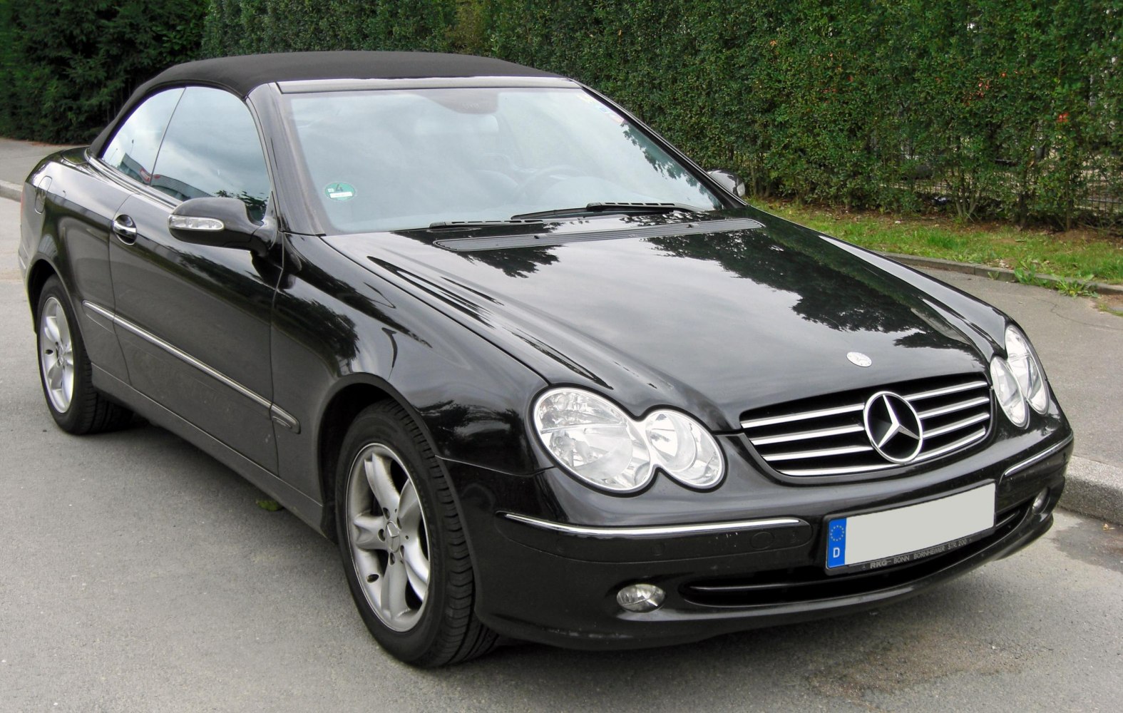 Black convertible with dual rounded headlights and classic front grill