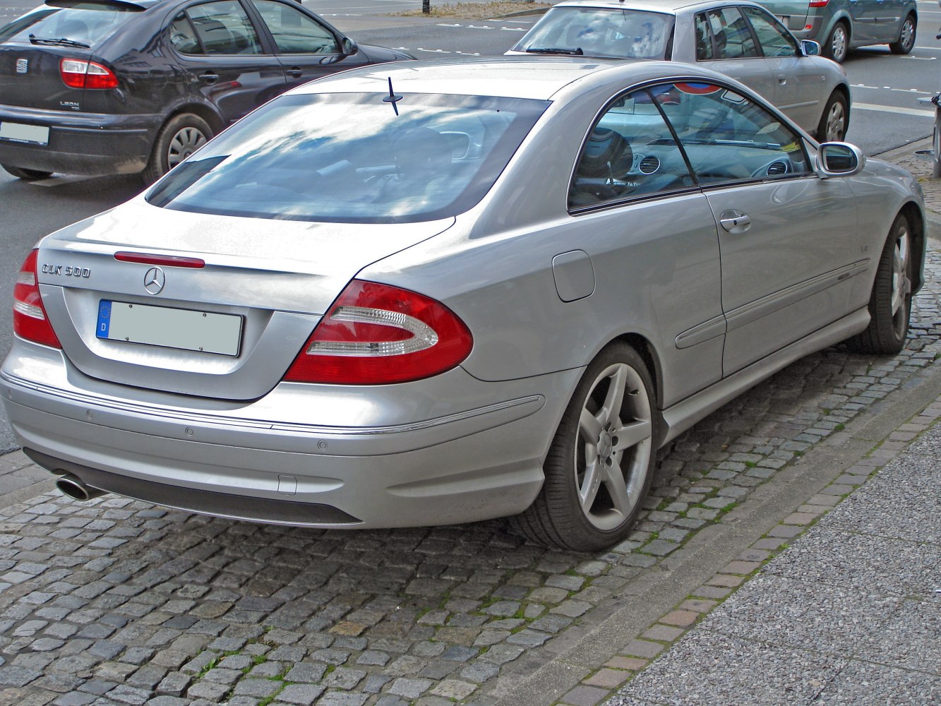Silver coupe rear view with distinct tail lights and alloy wheels