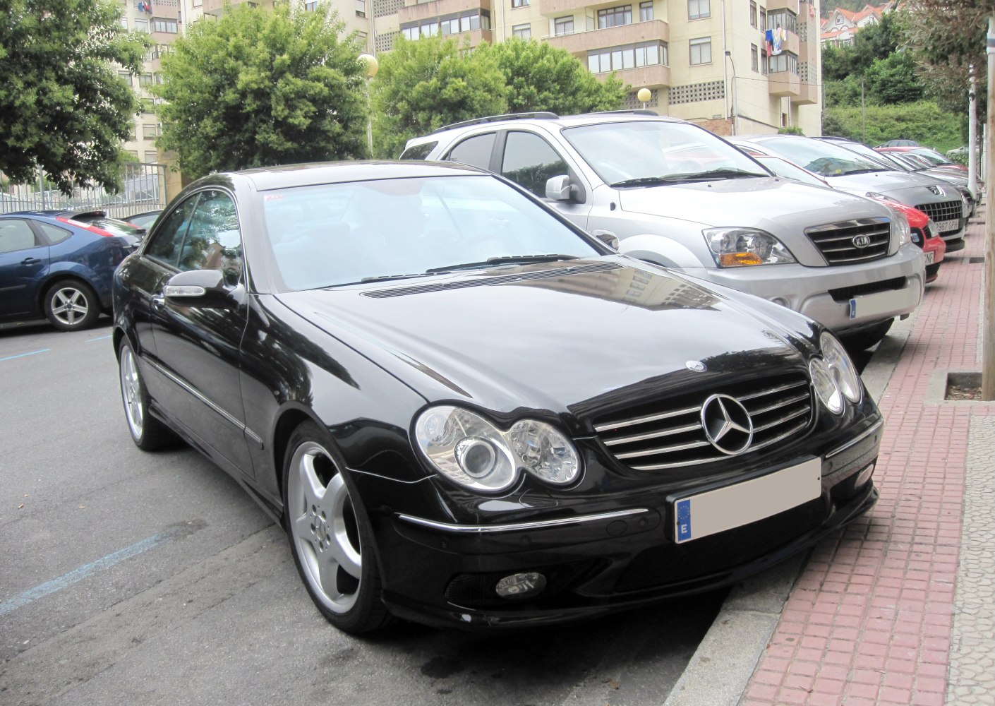Front view of a black coupe with quad headlights and alloy wheels