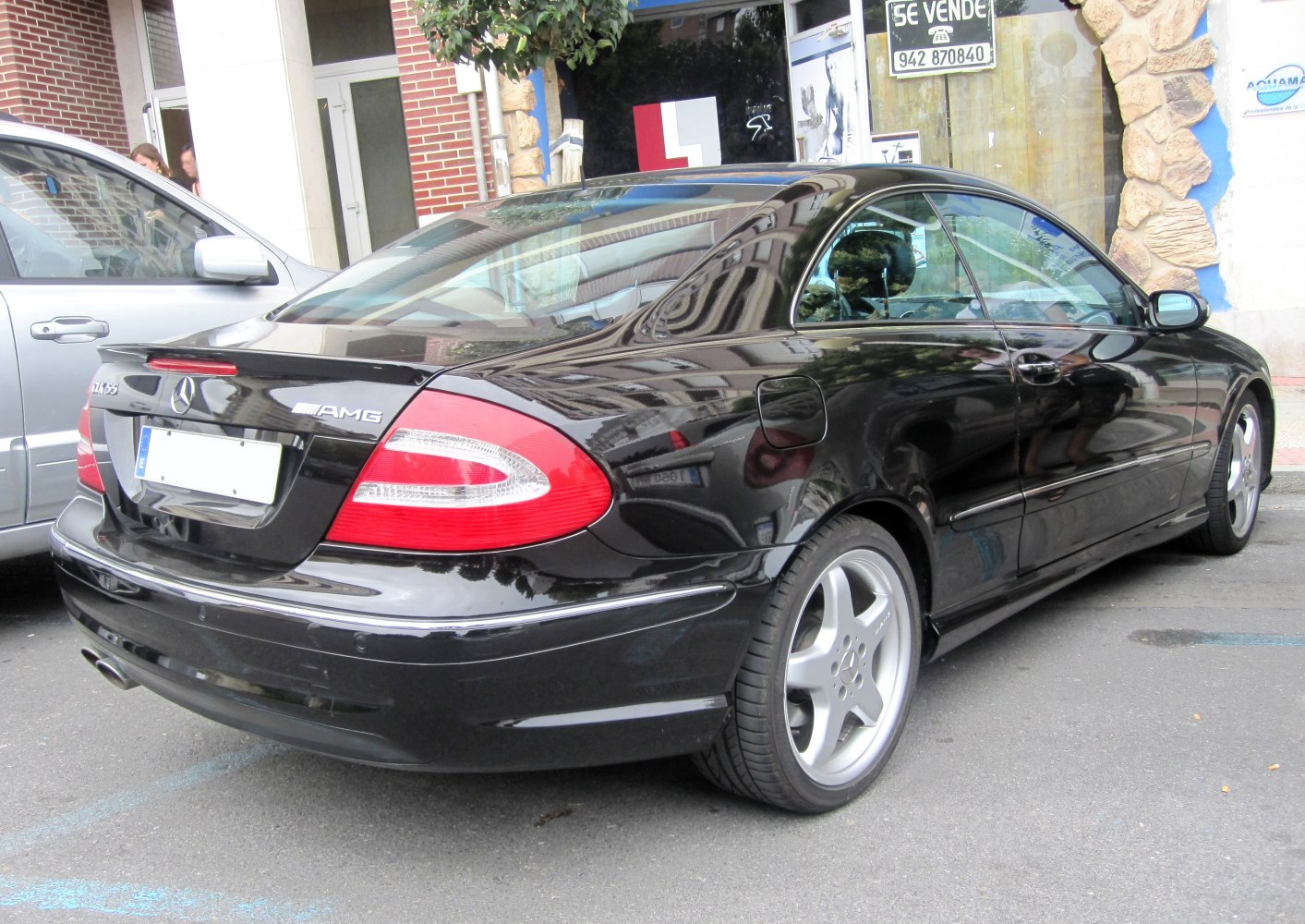 Rear view of black coupe highlighting tail lights and AMG wheels