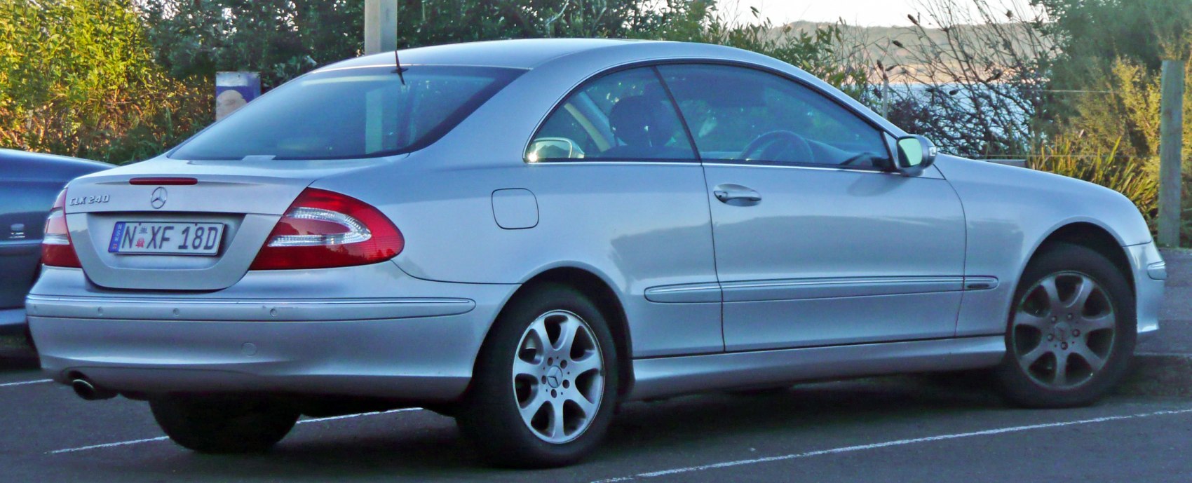 Rear side profile of a silver coupe with alloy wheels and distinct tail lights