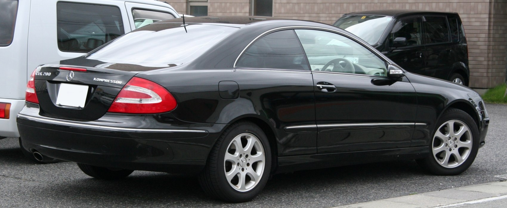 Black coupe rear side with distinctive taillights and alloy wheels
