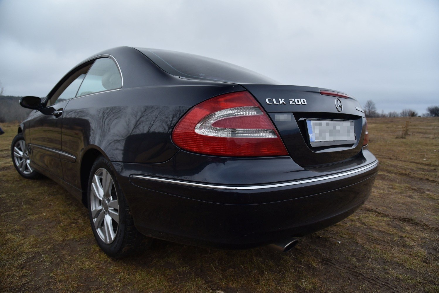 Rear view with tail lights and chrome trim of a luxury coupe