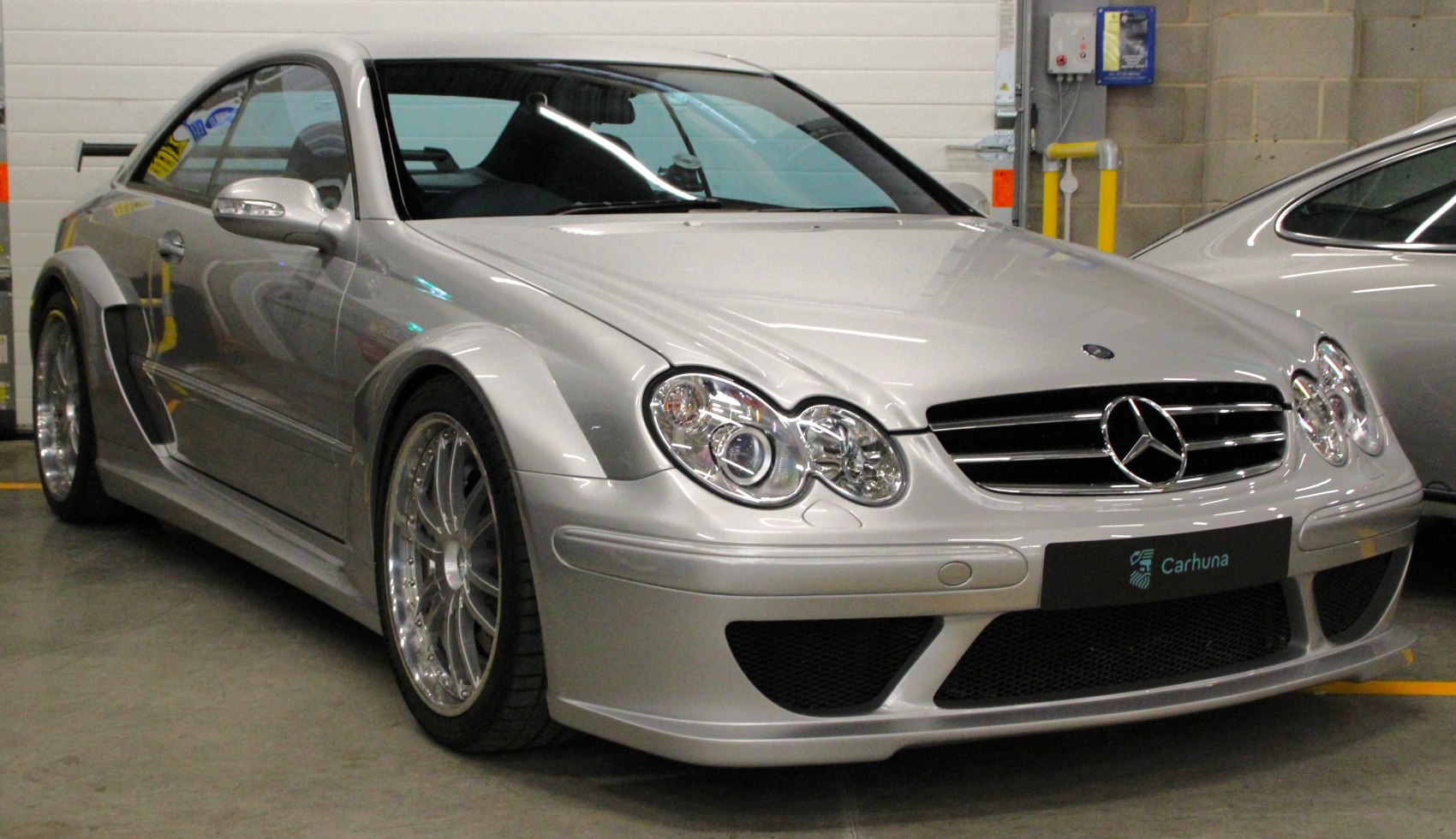 Front view of silver coupe with dual headlights and wide sporty fenders