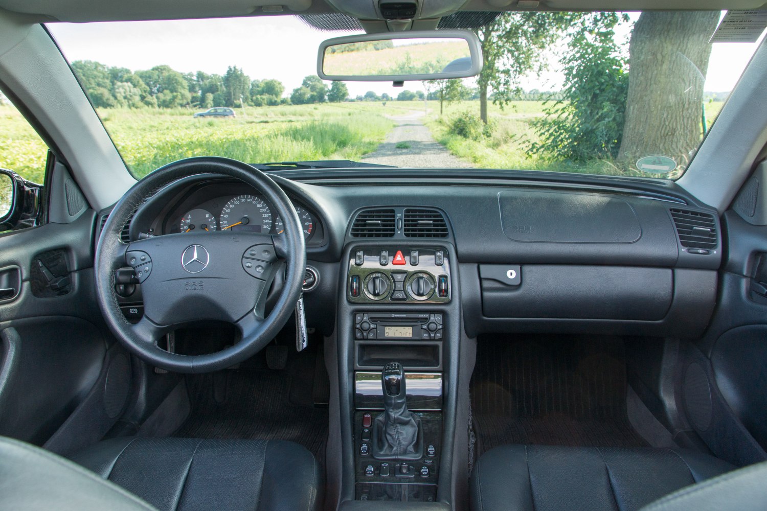 Interior dashboard and steering wheel with center console of a classic coupe.