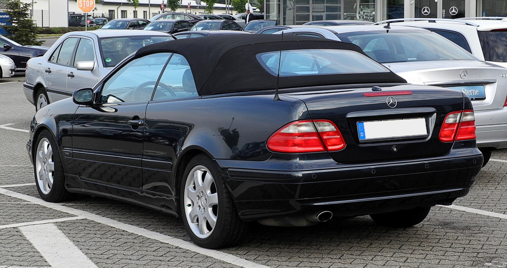 Rear and side view of black convertible with soft-top roof