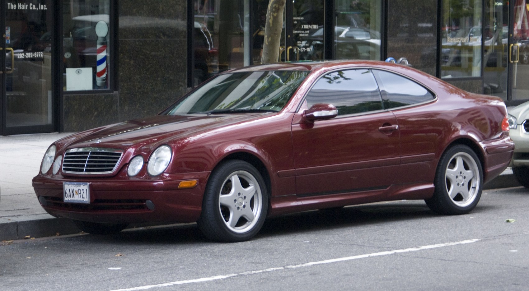 Dual round headlights and five-spoke alloy wheels of a luxury coupe