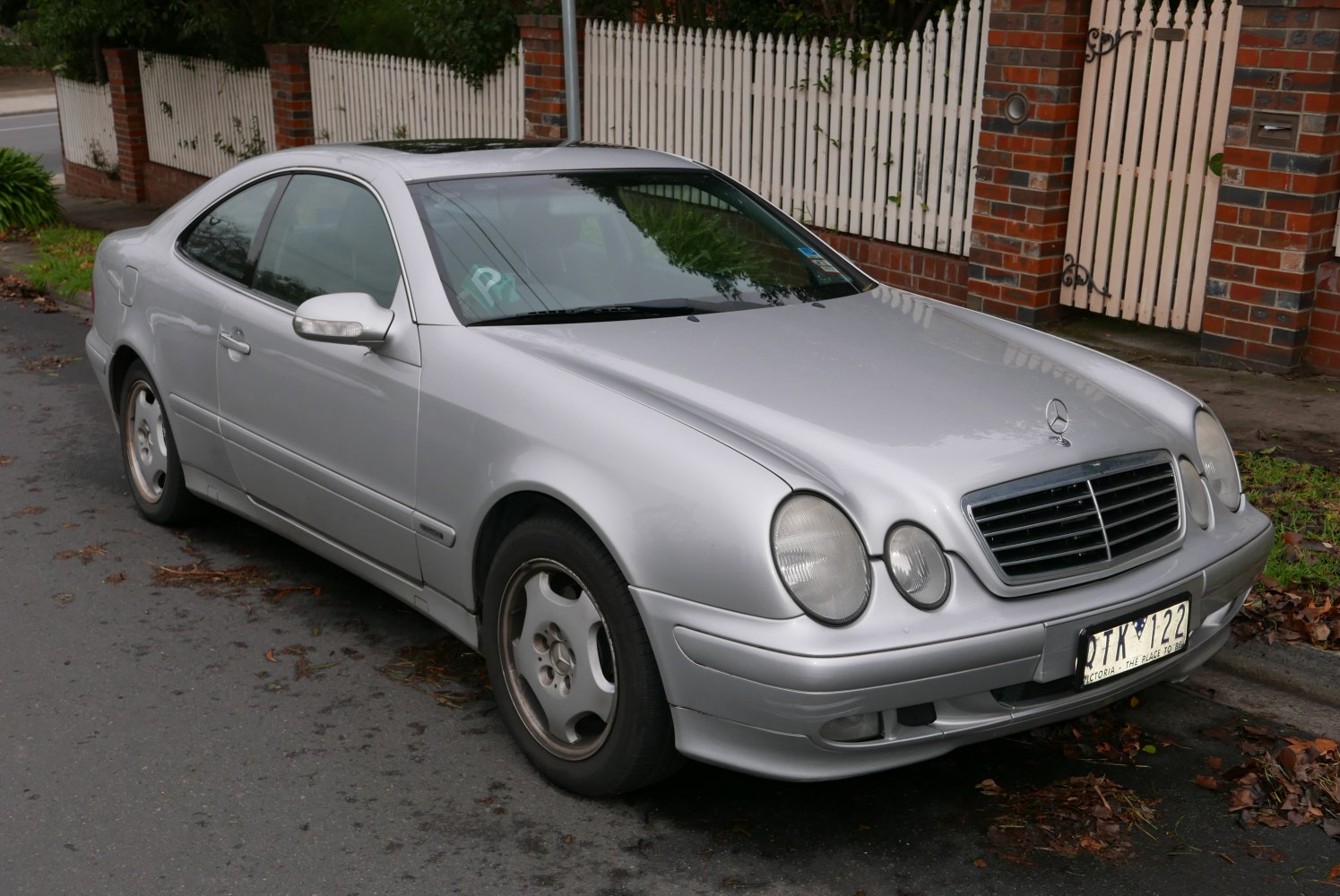 Silver two-door coupe with round headlights and classic grille