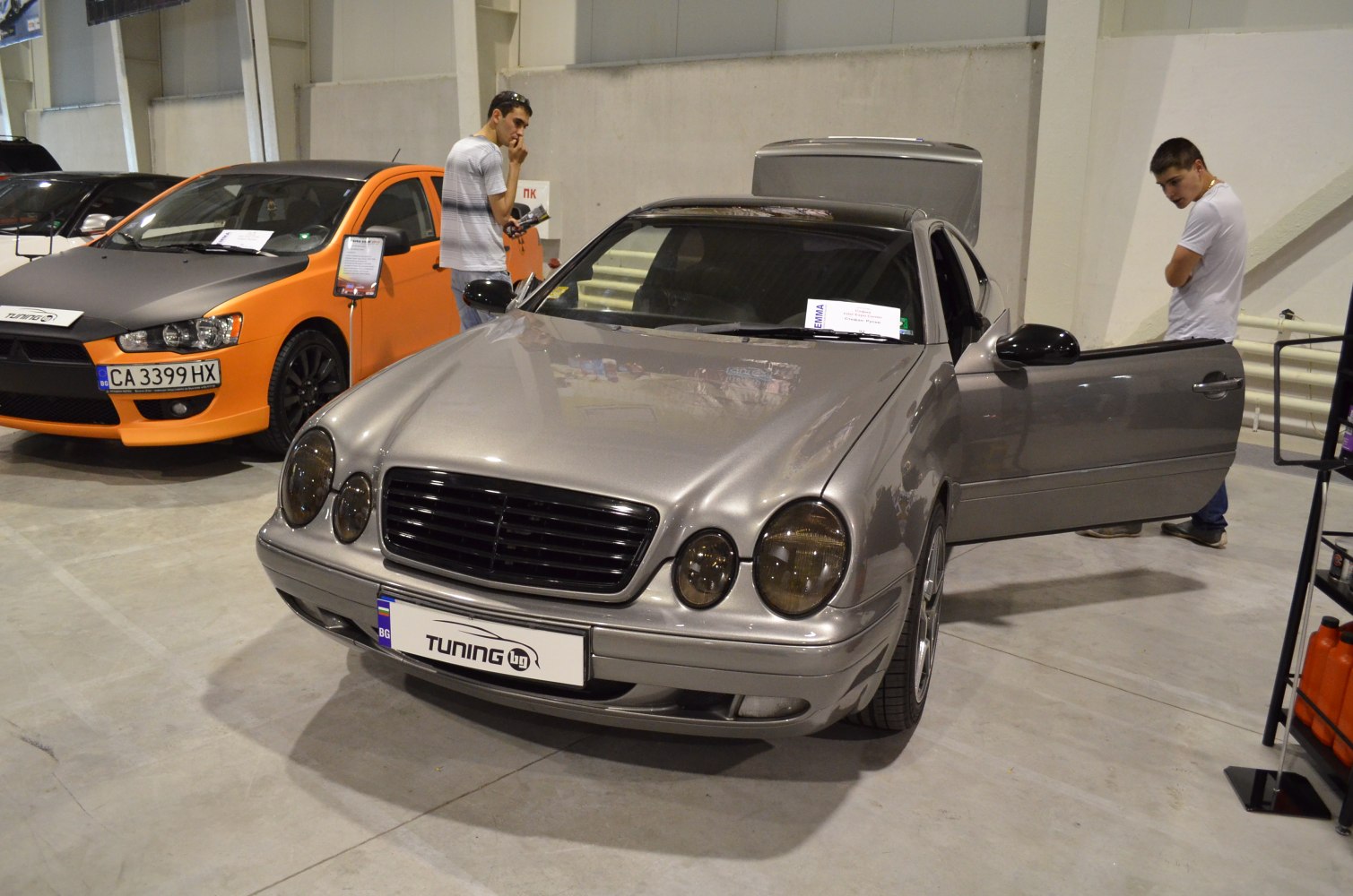 Dual rounded headlights and black front grille on a silver car