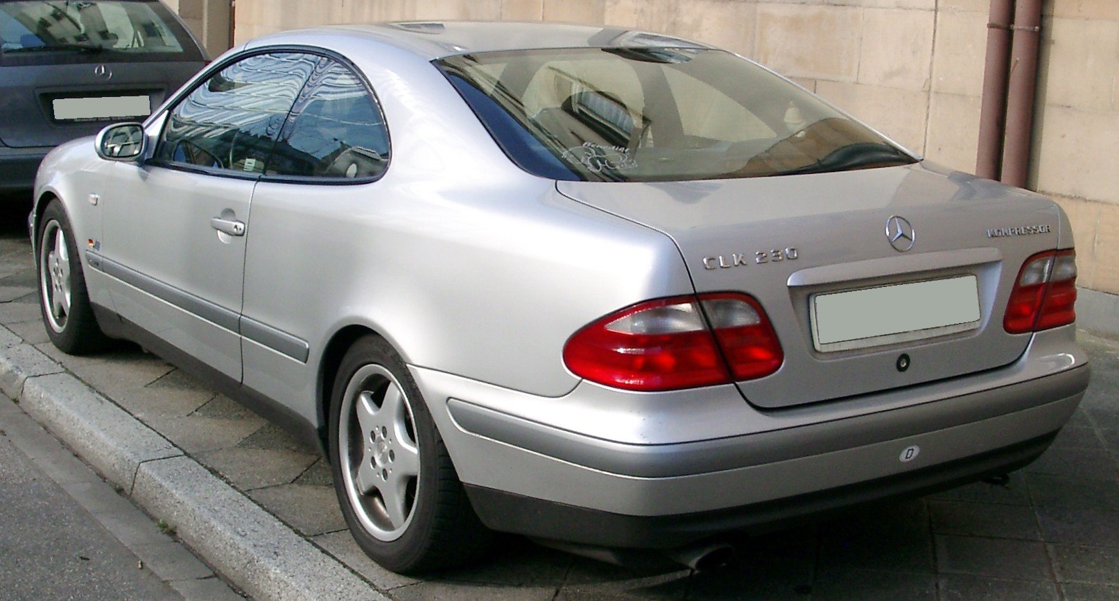 Rear view of a silver two-door coupe with distinctive tail lights.