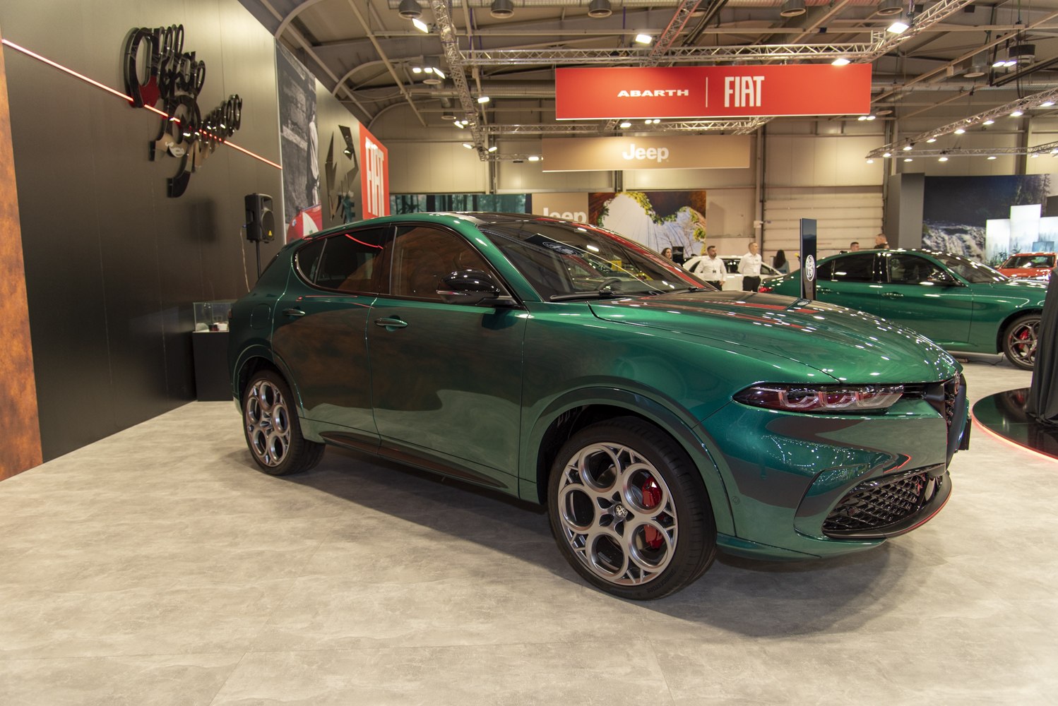 Green metallic SUV with sleek headlights and alloy wheels