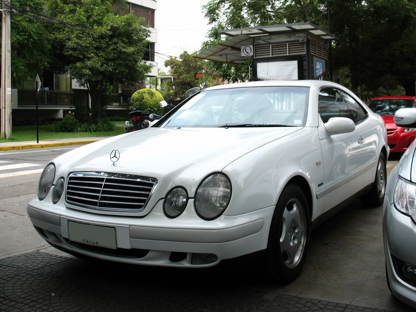 Front view showing dual round headlights and chrome grille on a coupe.