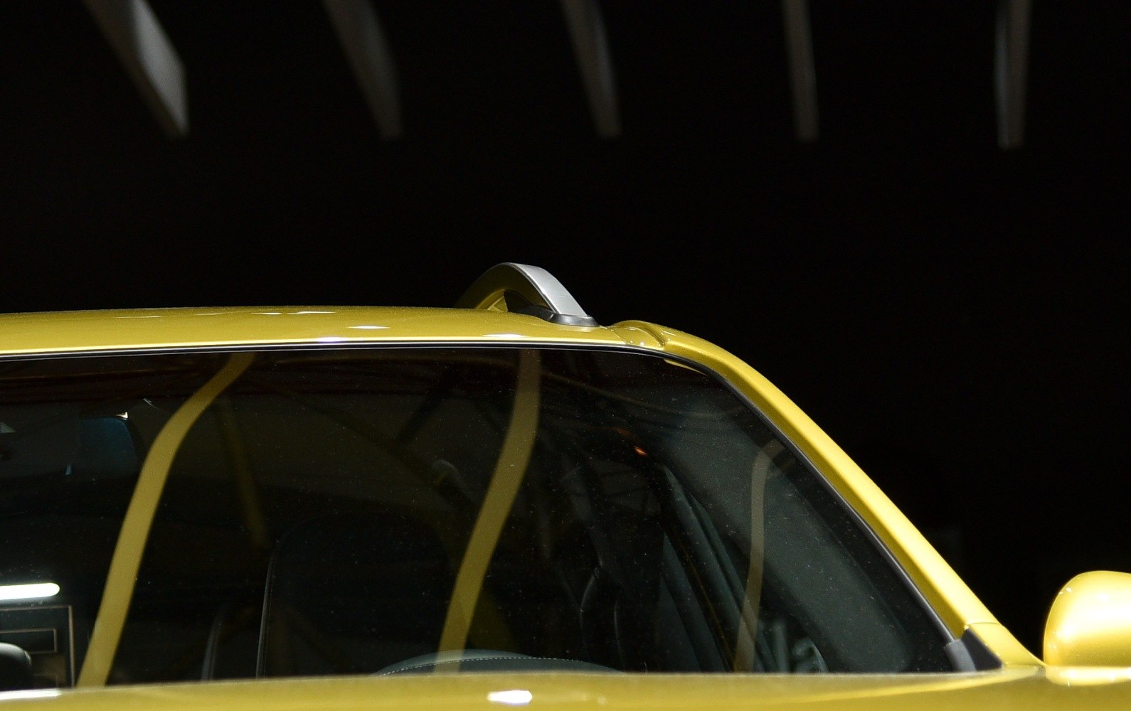 Close-up of roof rails and sunroof on yellow pickup.