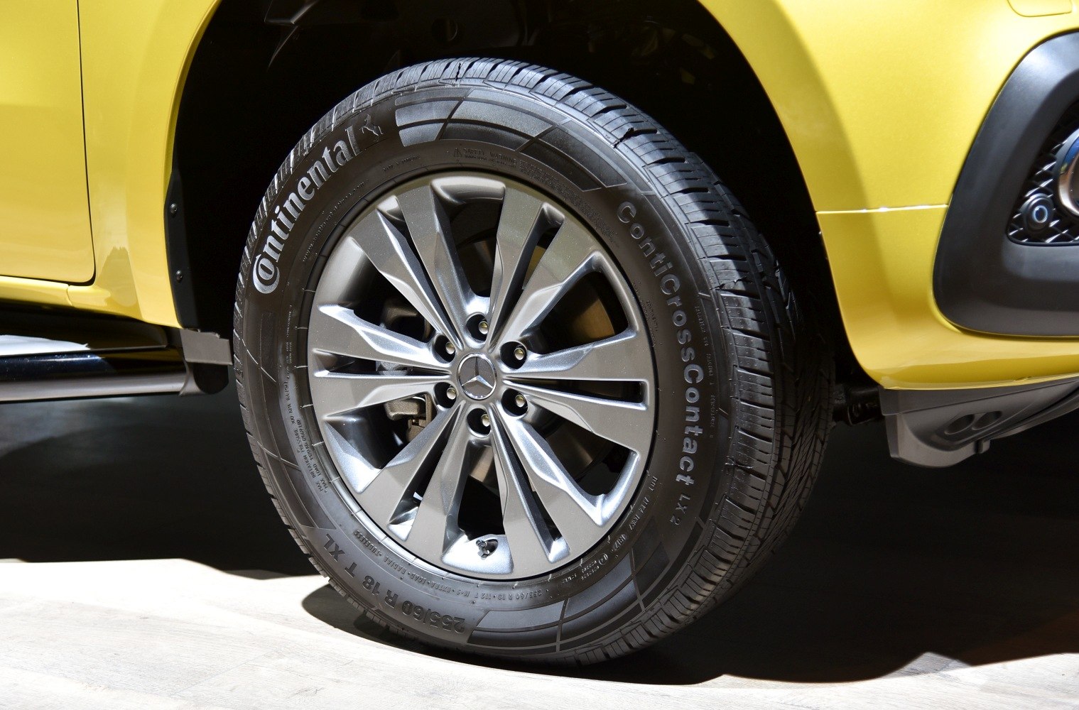 Close-up of alloy wheel with Continental tire on yellow vehicle