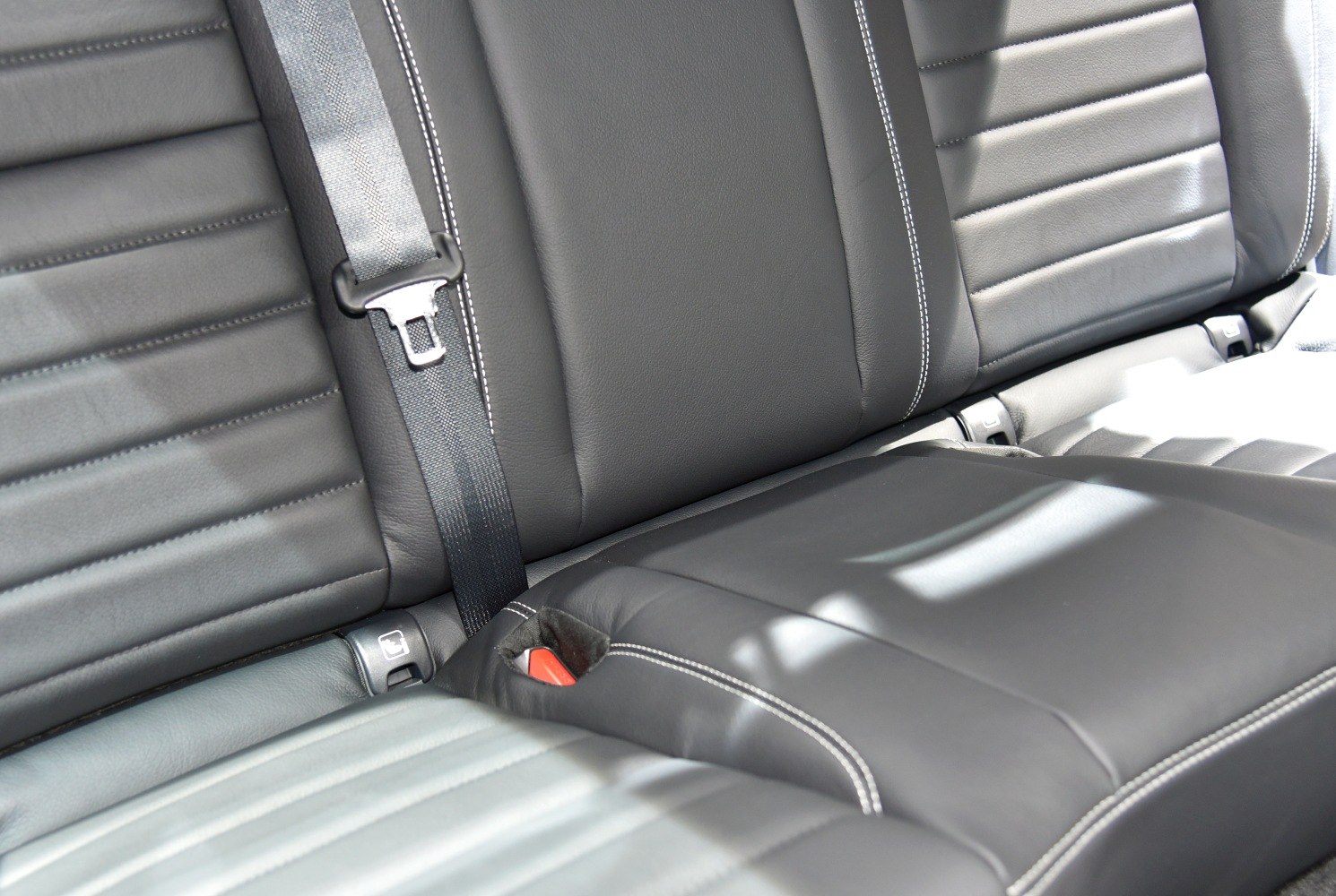 Black leather rear seat with seat belt and white stitching