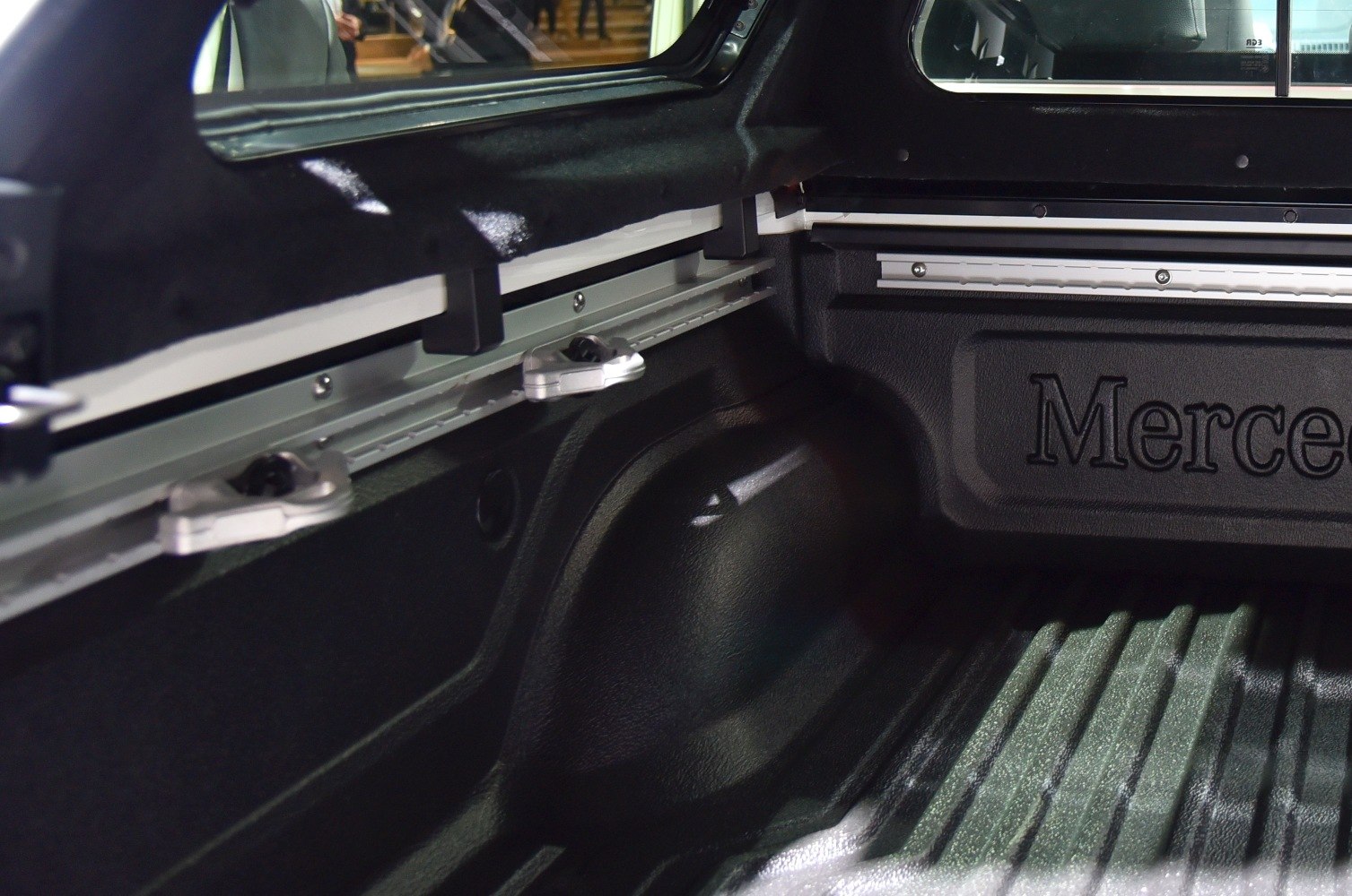 Pickup truck cargo bed interior with securing clamps and textured bed liner