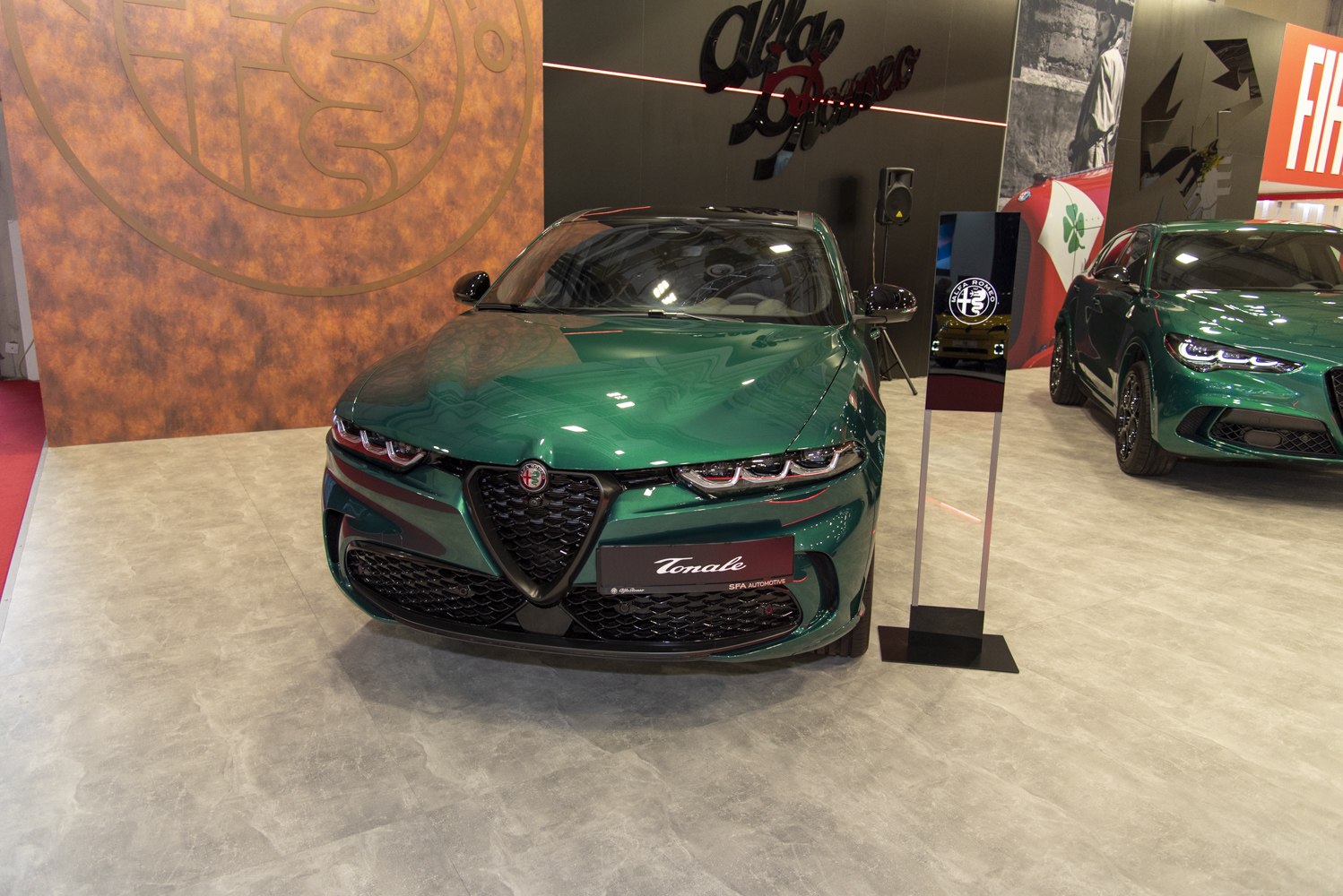 Front view of a green car with signature Alfa Romeo grille and quad headlights