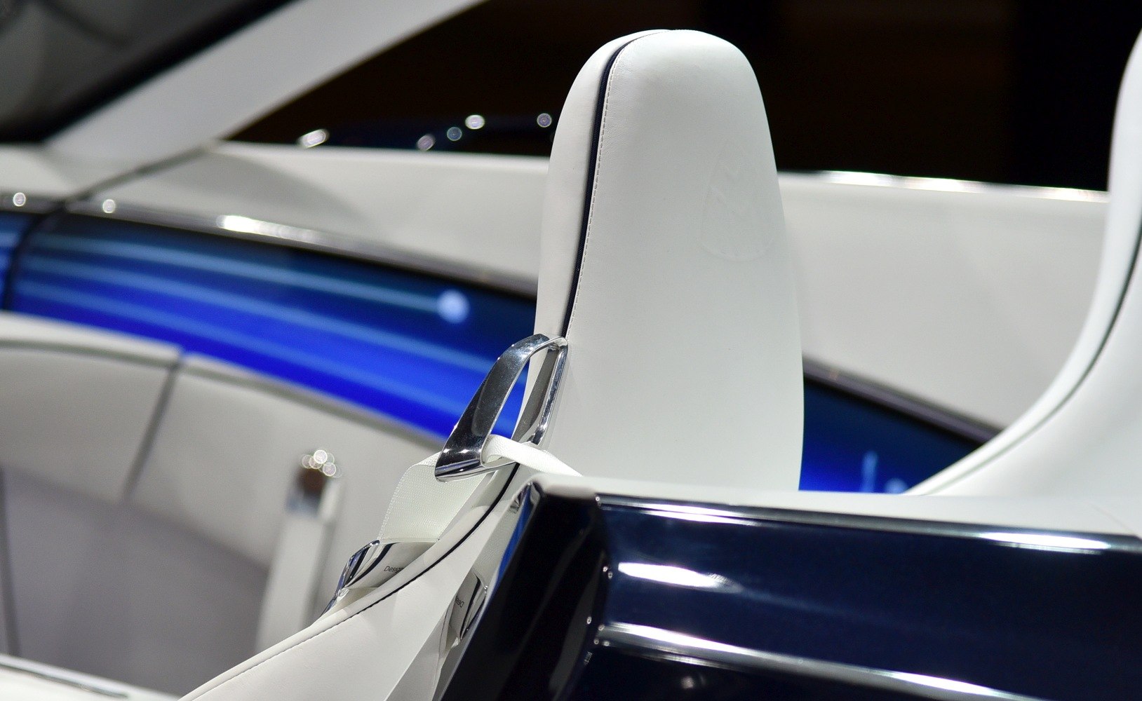 White leather car seat with chrome seatbelt buckle and blue ambient lighting